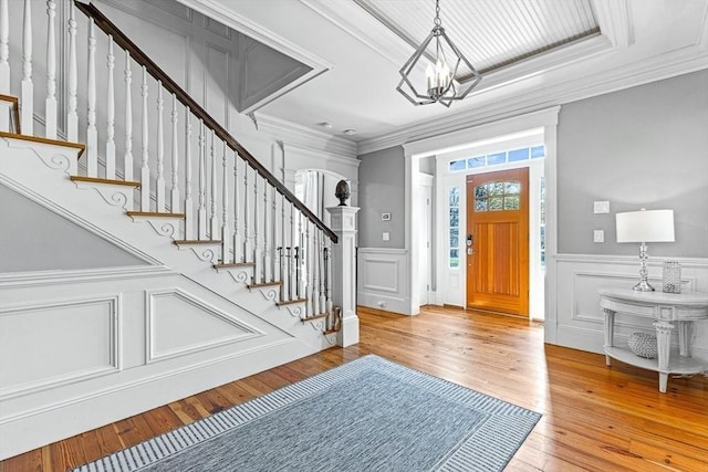 25 Wedgemere Ave, Winchester, MA 01890 - entryway with a chandelier, stairway, hardwood / wood-style floors, a wainscoted wall, and a decorative wall