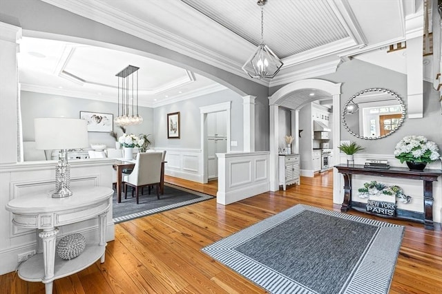 25 Wedgemere Ave, Winchester, MA 01890 - foyer entrance featuring arched walkways, wood-type flooring, a decorative wall, ornate columns, and ornamental molding
