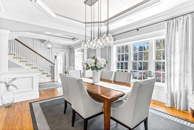 25 Wedgemere Ave, Winchester, MA 01890 - dining space featuring ornamental molding, hardwood / wood-style floors, stairs, arched walkways, and a raised ceiling
