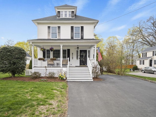 american foursquare style home with a porch, driveway, and a front yard