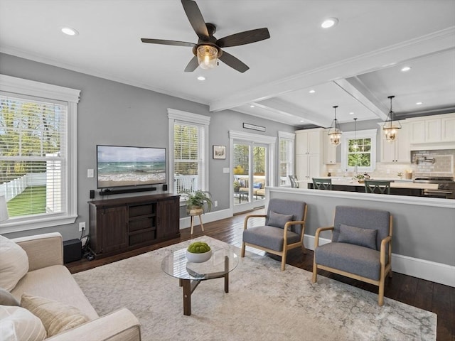 living room featuring a ceiling fan, wood finished floors, beamed ceiling, ornamental molding, and recessed lighting