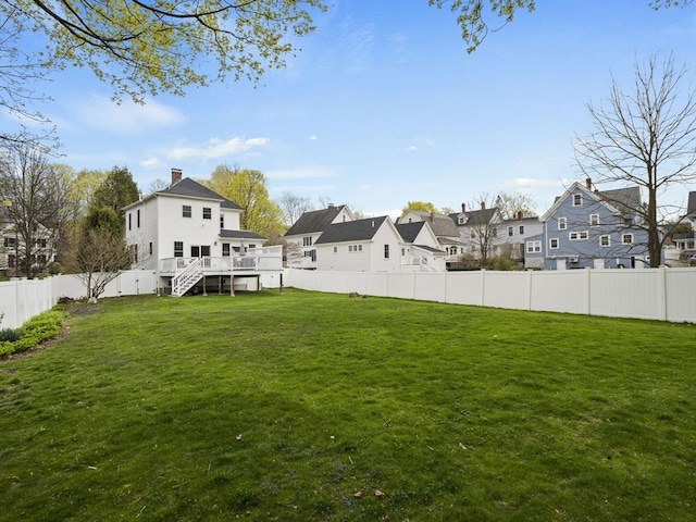 view of yard with a fenced backyard, stairway, a wooden deck, and a residential view