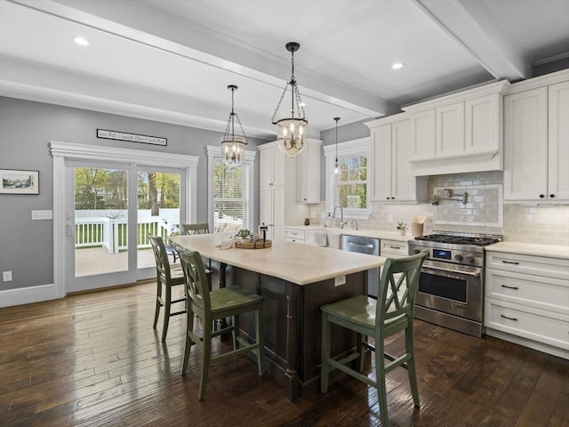kitchen featuring appliances with stainless steel finishes, beamed ceiling, and dark wood-type flooring