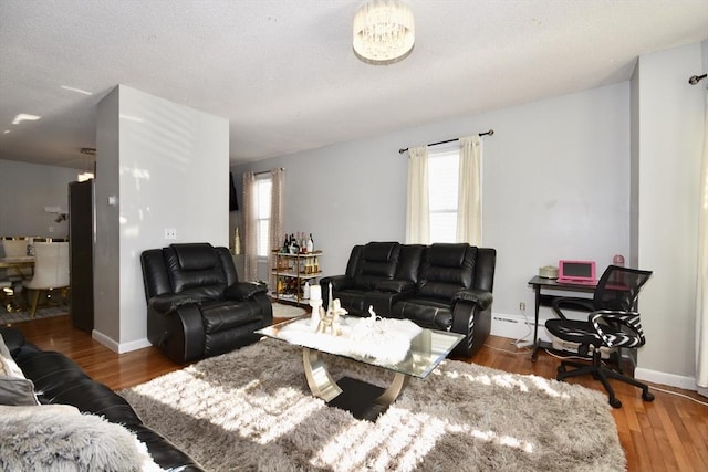 living room with baseboard heating, dark hardwood / wood-style floors, and a textured ceiling