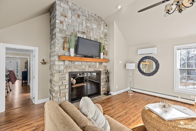 living room with a fireplace, a wall mounted AC, baseboard heating, and wood finished floors