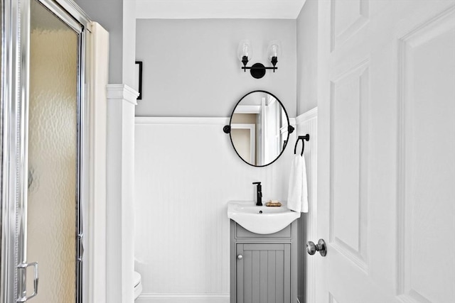 bathroom with a stall shower, vanity, and toilet