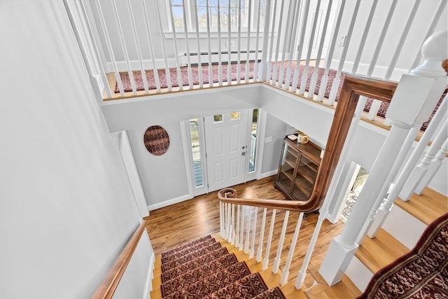 entryway with a baseboard radiator, baseboards, a wealth of natural light, and wood finished floors