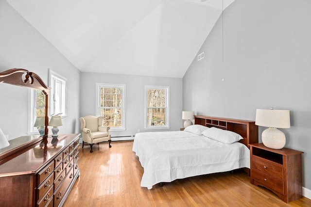 bedroom featuring high vaulted ceiling, light wood finished floors, and visible vents