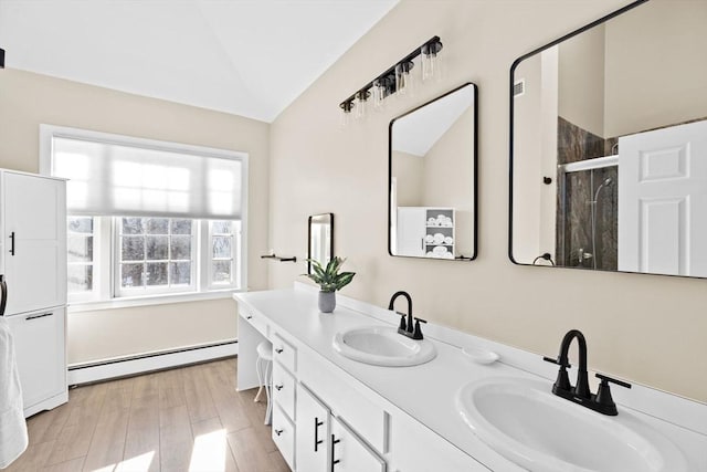 full bathroom featuring a baseboard heating unit, vaulted ceiling, a sink, and a shower stall