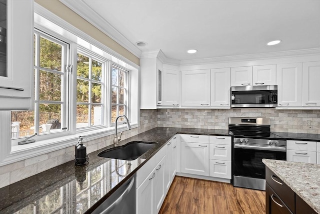 kitchen with white cabinetry, appliances with stainless steel finishes, tasteful backsplash, and a sink