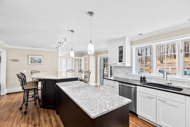 kitchen with a sink, a kitchen island, decorative backsplash, dishwasher, and dark wood finished floors