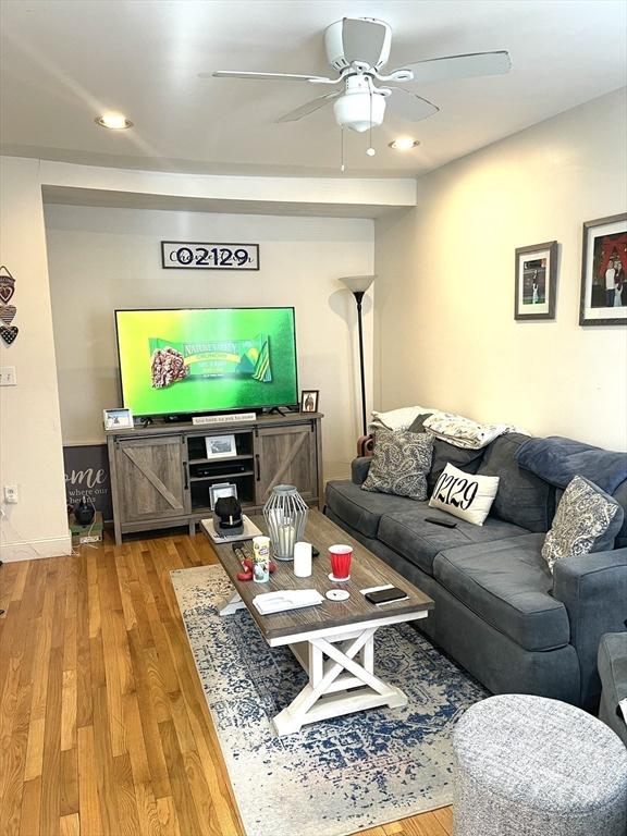 living room featuring light wood-type flooring and ceiling fan