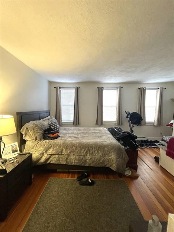 bedroom with a textured ceiling and dark hardwood / wood-style flooring