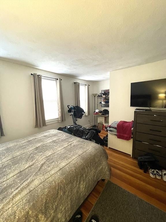 bedroom with dark wood-type flooring and a textured ceiling