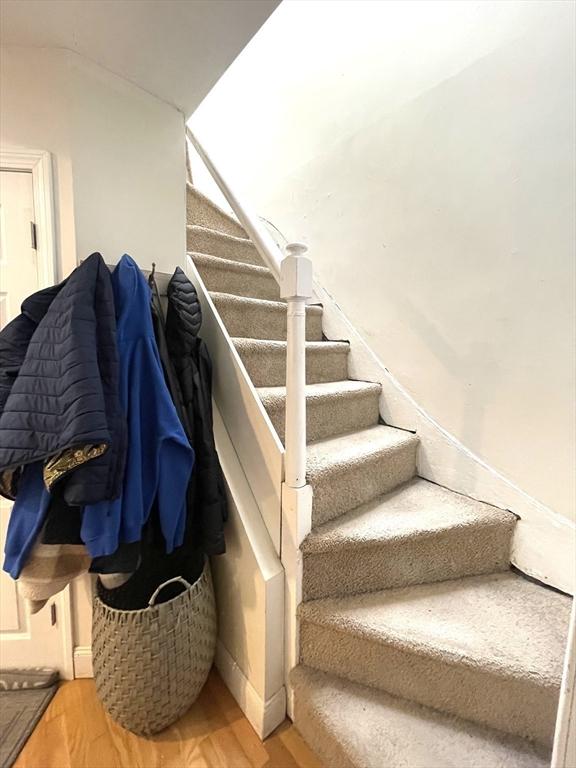 stairs featuring hardwood / wood-style floors