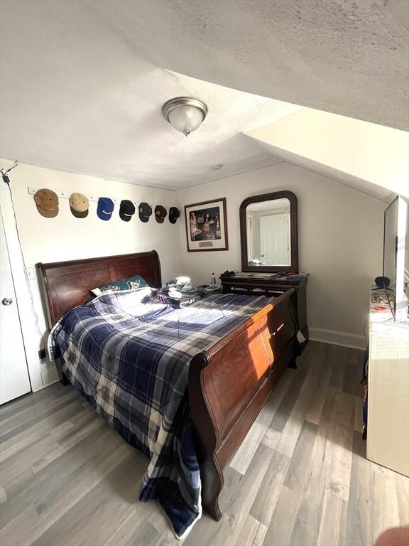 bedroom featuring light hardwood / wood-style floors and a textured ceiling