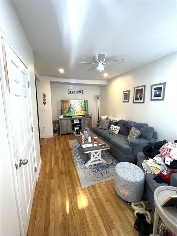 living room with ceiling fan and light hardwood / wood-style flooring