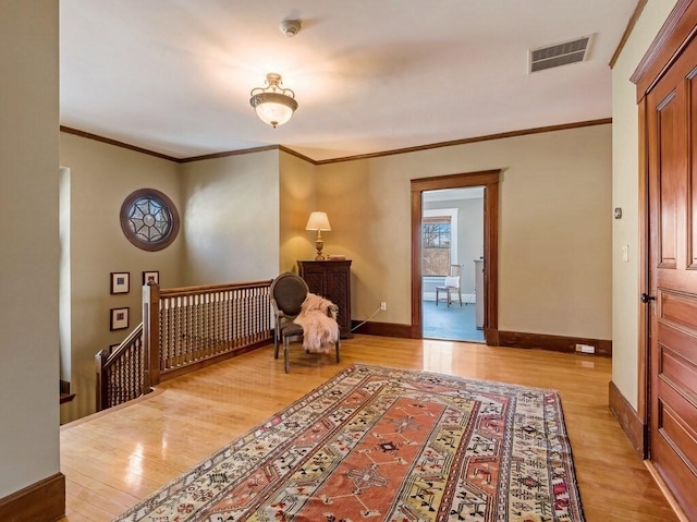 living area featuring ornamental molding and light hardwood / wood-style floors