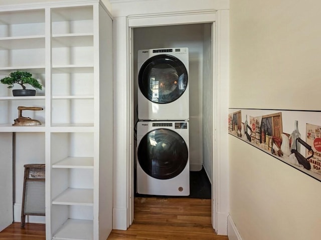 washroom with dark hardwood / wood-style floors and stacked washer / dryer