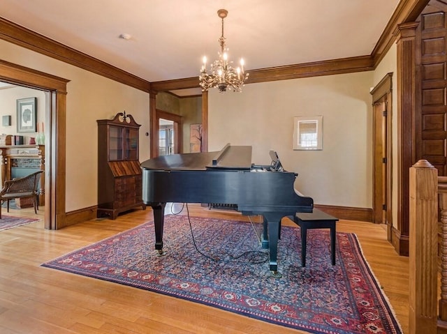 miscellaneous room featuring ornamental molding, an inviting chandelier, and light hardwood / wood-style floors