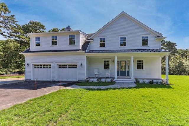 view of front of property with a garage, a front yard, and covered porch