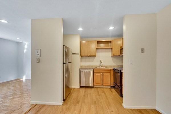 kitchen featuring stainless steel appliances, a sink, recessed lighting, baseboards, and open shelves