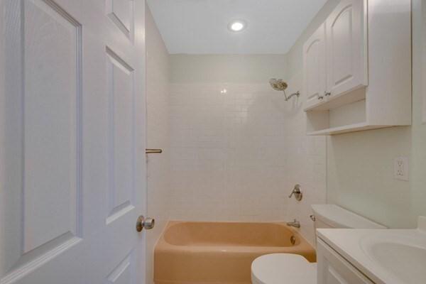 bathroom with toilet, tub / shower combination, vanity, and recessed lighting