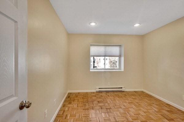 unfurnished room with a baseboard radiator, baseboards, and recessed lighting