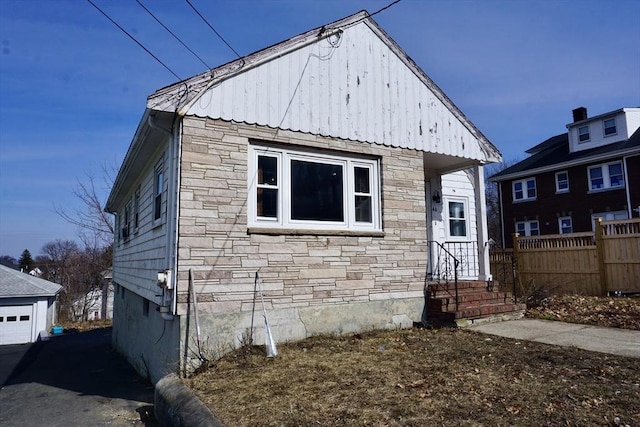 bungalow with stone siding and fence