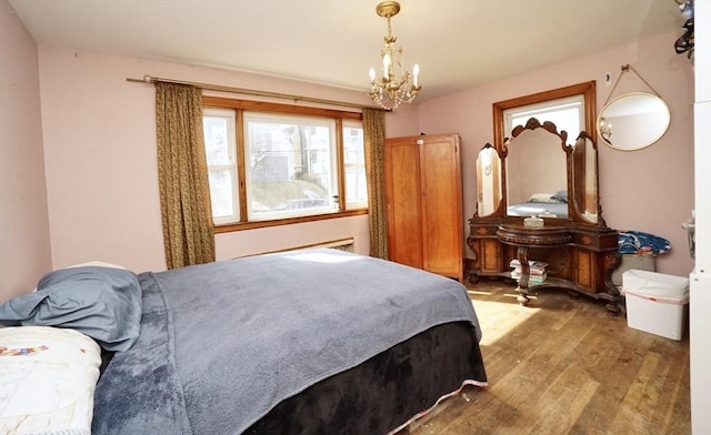 bedroom featuring wood-type flooring and an inviting chandelier