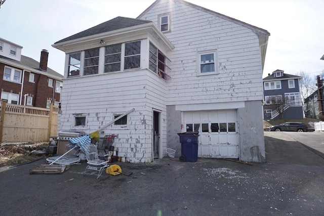 exterior space featuring a garage and fence