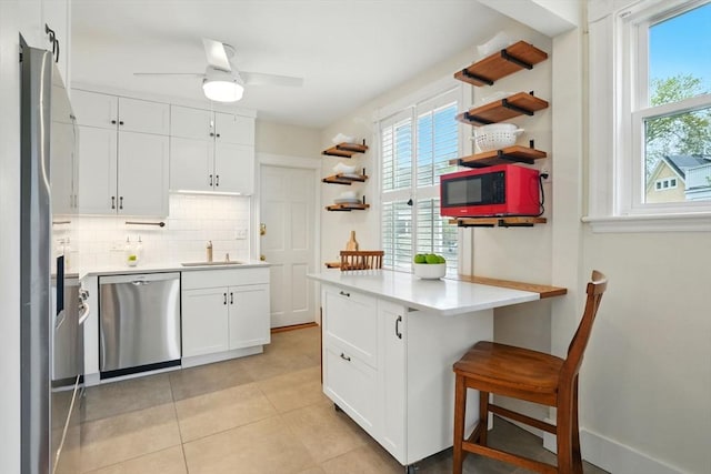 kitchen with stainless steel appliances, a sink, open shelves, and healthy amount of natural light