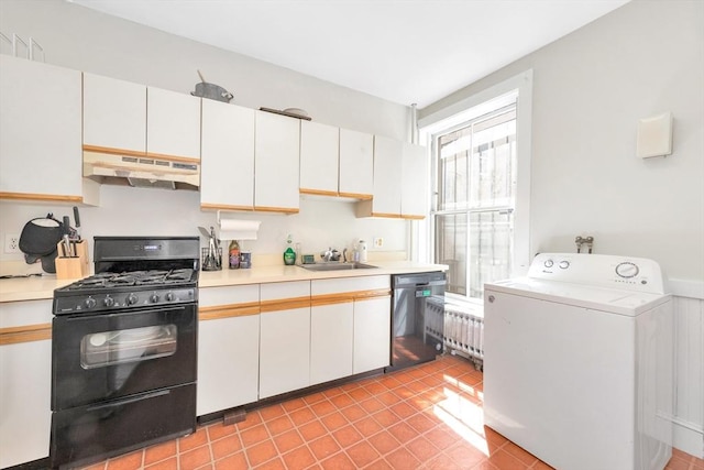 kitchen with under cabinet range hood, washer / dryer, black range with gas stovetop, dishwasher, and light countertops