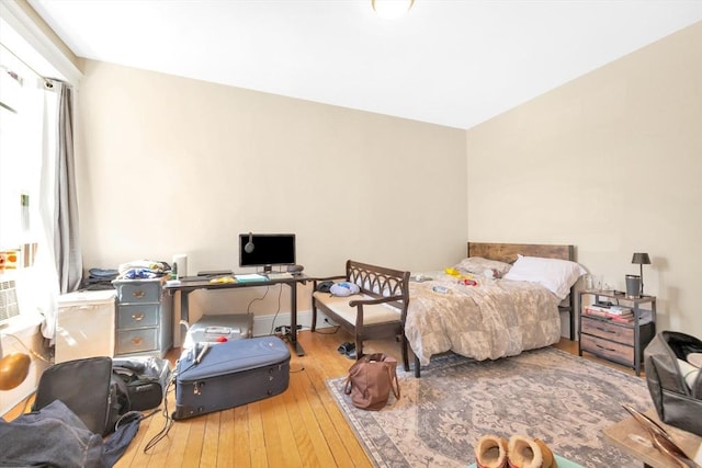 bedroom with hardwood / wood-style flooring and an office area