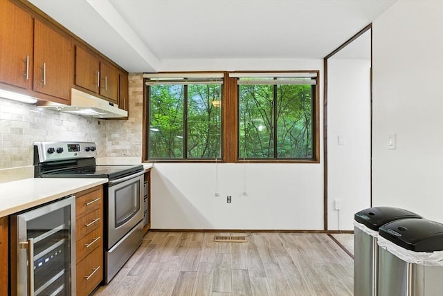 611 Old Stone Brk Unit 611, Acton, MA 01718 - kitchen with beverage cooler, stainless steel range with electric cooktop, light wood-style flooring, brown cabinetry, and light countertops