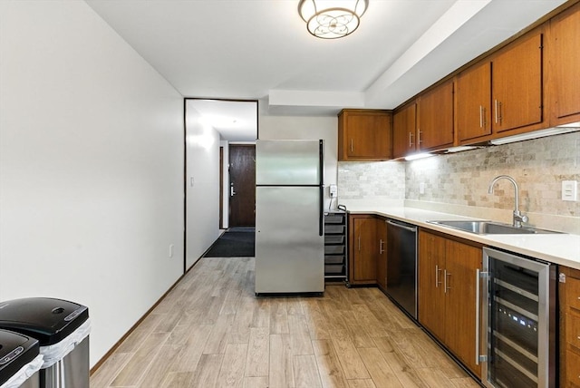 611 Old Stone Brk Unit 611, Acton, MA 01718 - kitchen with stainless steel appliances, wine cooler, brown cabinetry, light wood-style flooring, and decorative backsplash