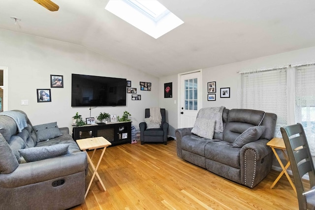 living room with hardwood / wood-style flooring and lofted ceiling with skylight