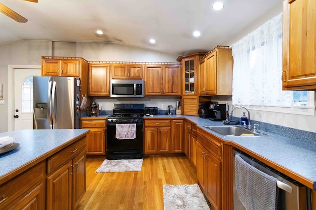 kitchen with light wood-type flooring, ceiling fan, vaulted ceiling, sink, and stainless steel appliances