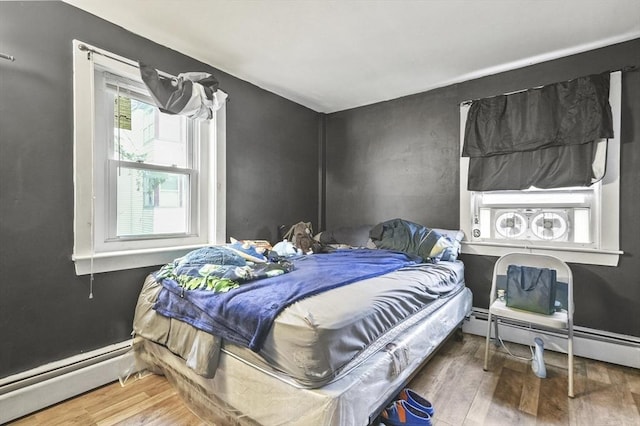 18 Cedar Ct, Lowell, MA 01852 - bedroom featuring a baseboard heating unit, wood finished floors, and a baseboard radiator