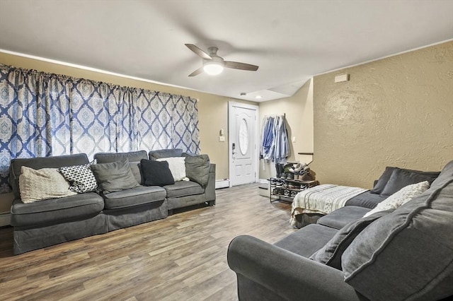18 Cedar Ct, Lowell, MA 01852 - living area with a textured wall, wood finished floors, ceiling fan, and a baseboard heating unit