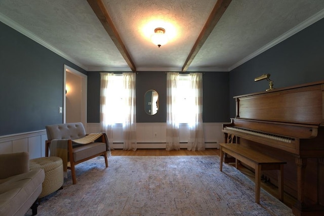 sitting room with beamed ceiling, ornamental molding, wood finished floors, and a wainscoted wall