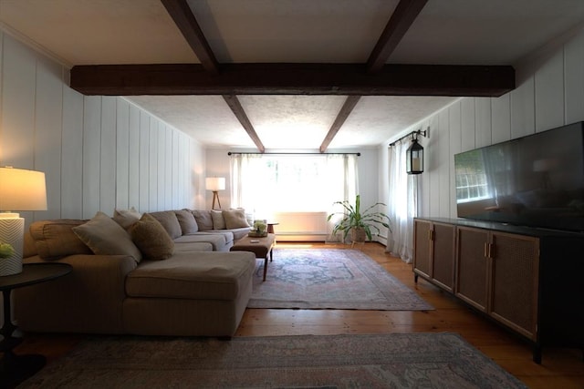 living room featuring light wood-type flooring, baseboard heating, and beamed ceiling