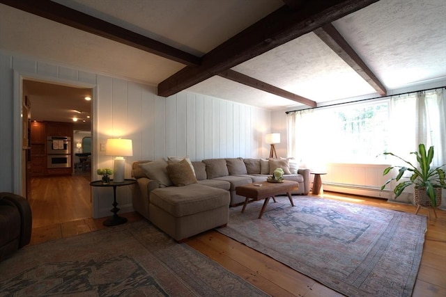 living area with baseboard heating, beamed ceiling, and wood-type flooring