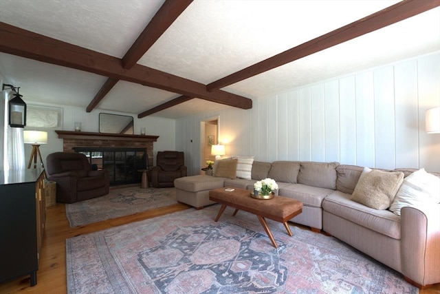 living room featuring a fireplace, wood finished floors, and beam ceiling