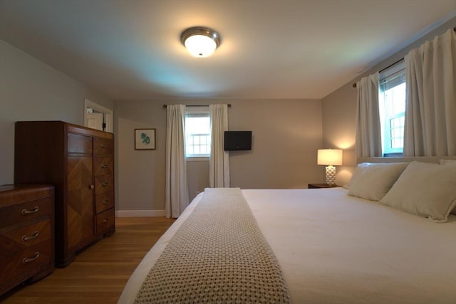 bedroom with baseboards and light wood-style floors