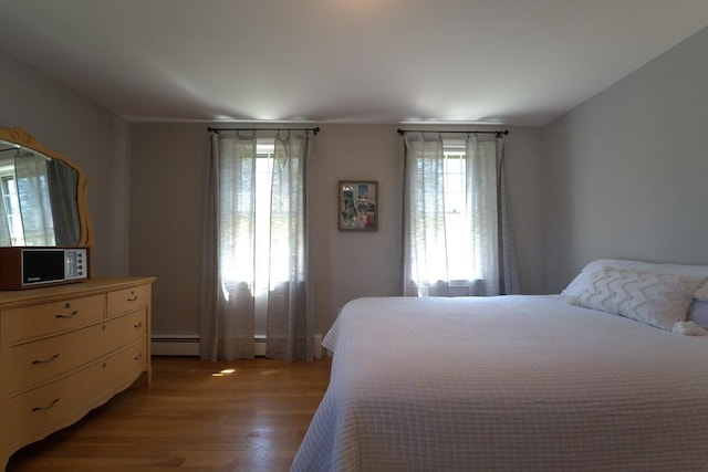 bedroom featuring a baseboard radiator and light wood finished floors