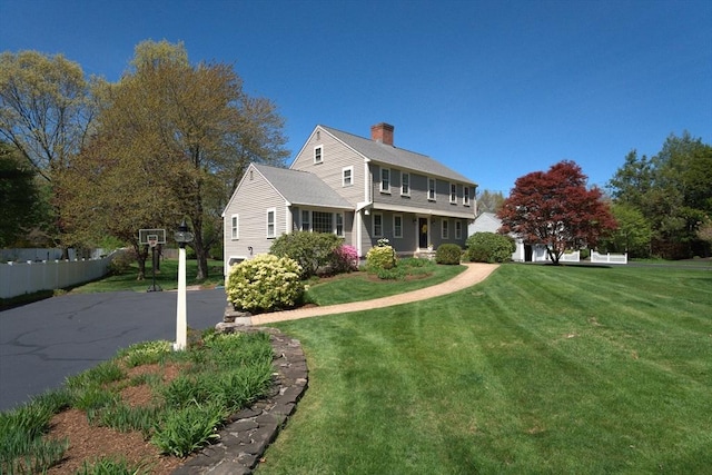 view of front of property featuring a chimney and a front yard