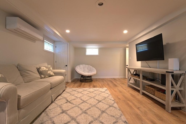 living area featuring recessed lighting, baseboards, light wood-style flooring, and a wall unit AC