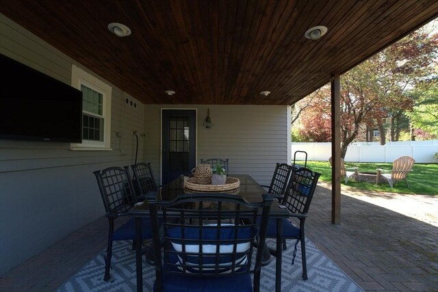 view of patio featuring fence, outdoor dining space, and a fire pit
