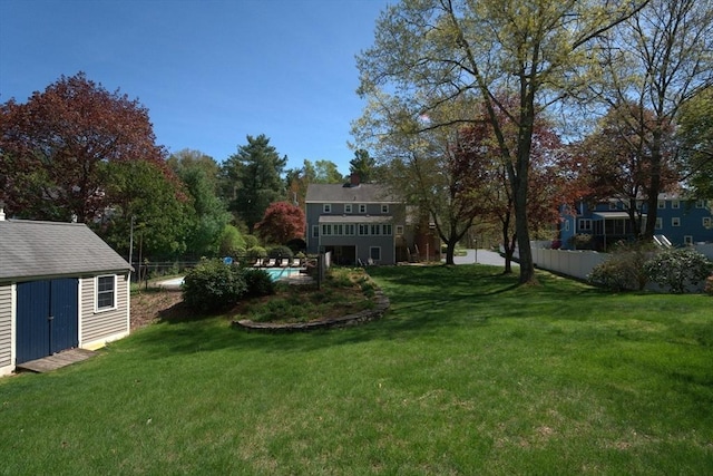 view of yard featuring an outdoor pool, fence, an outdoor structure, and a shed